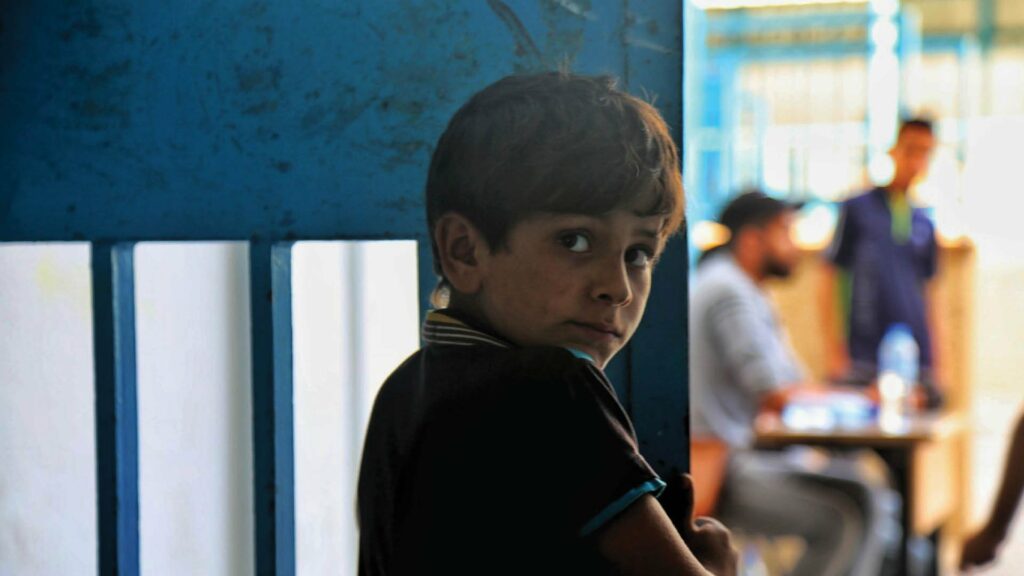 Ein Junge schaut ängstlich über seine Schulter.