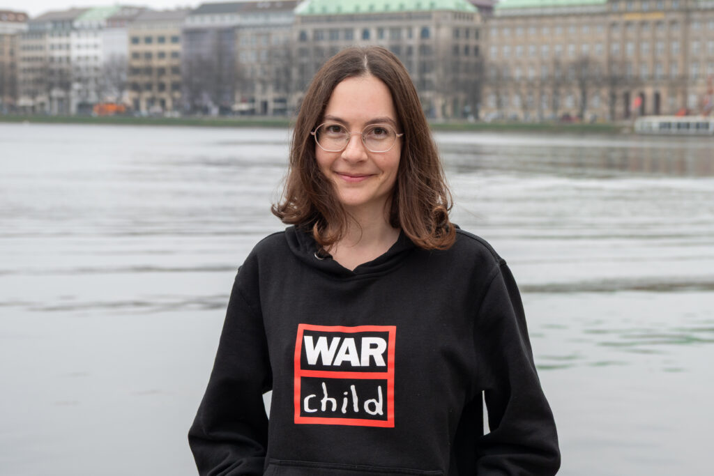 Porträt von War Child Deutschland Mitarbeiterin Philine Lehmann vor der Binnenalster in Hamburg