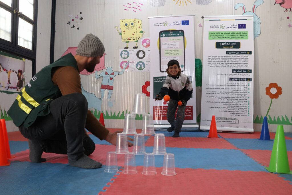 Walid (11) spielt mit einer Betreuungsperson