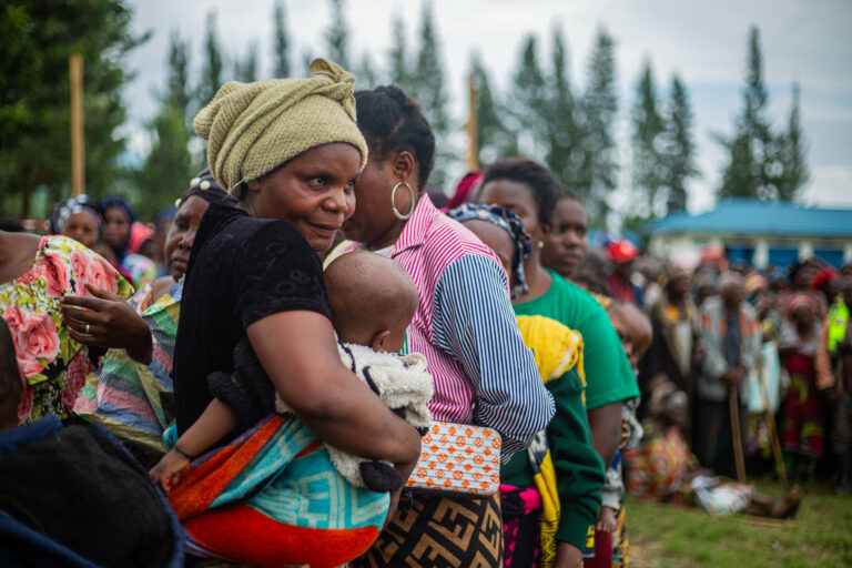 EIne Mutter hält ihr Kind im Arm inmitten vieler Menschen im Osten der DR Kongo